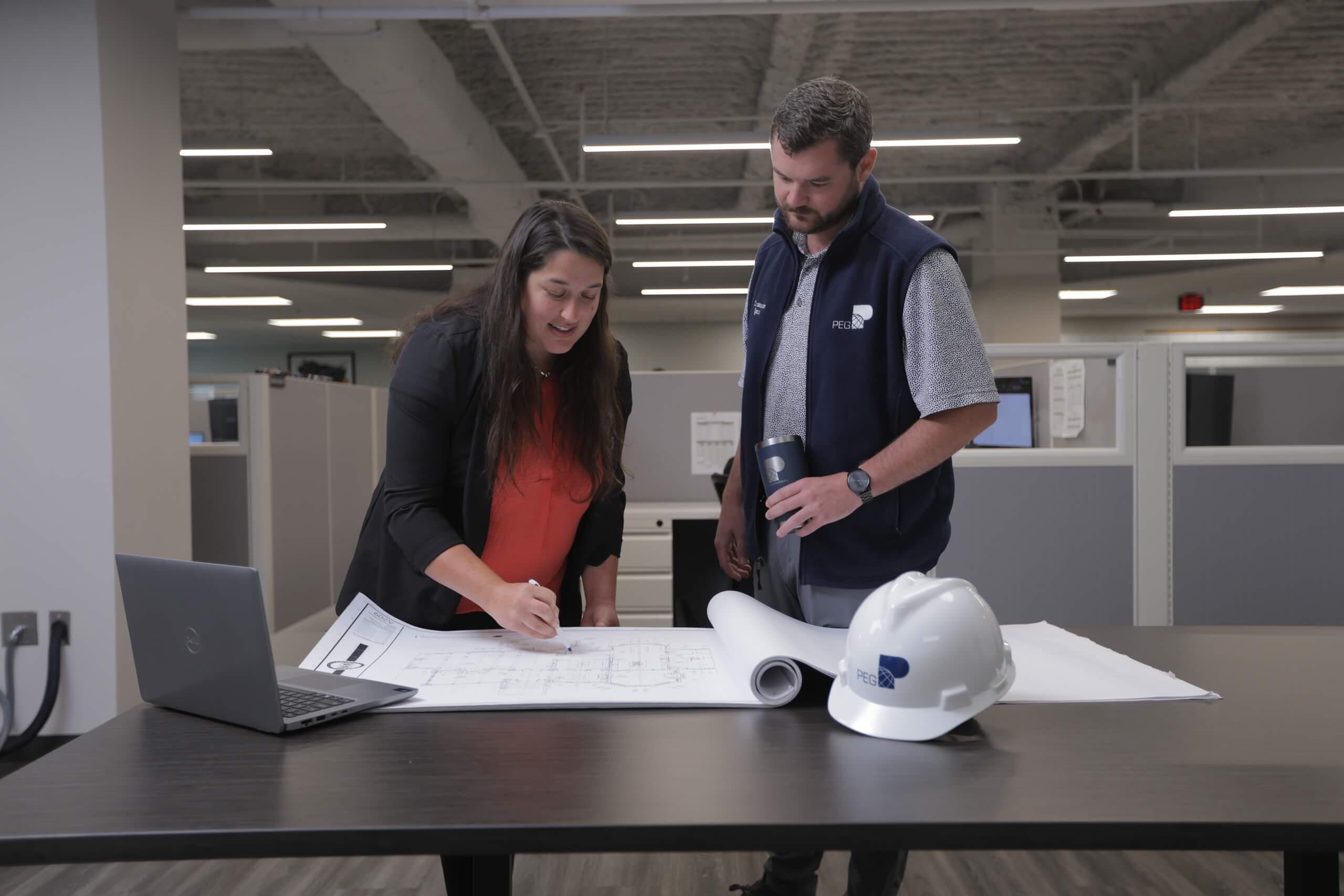 PEG engineers discussing a blueprint.